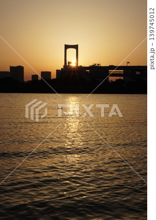 レインボーブリッジの主塔に沈む夕日と水面で魚が跳ねる瞬間 レインボーブリッジの主塔に沈む夕日と水面で魚が跳ねる瞬間 139745012