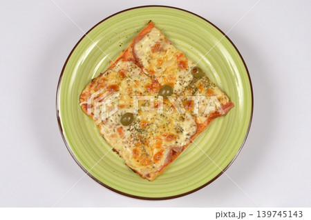 Square pizza slice with olives on a green plate Square pizza slice with olives on a green plate 139745143
