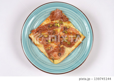 Square pizza slice with mortadella and pistachios Square pizza slice with mortadella and pistachios 139745144