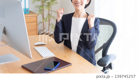 デスクトップパソコンで仕事するビジネスウーマン（ガッツポーズ） 139745257