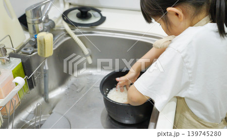 料理のお手伝いでお米を研ぐ子供 料理のお手伝いでお米を研ぐ子供 139745280