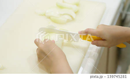 料理のお手伝いで野菜を切る子供 料理のお手伝いで野菜を切る子供 139745281