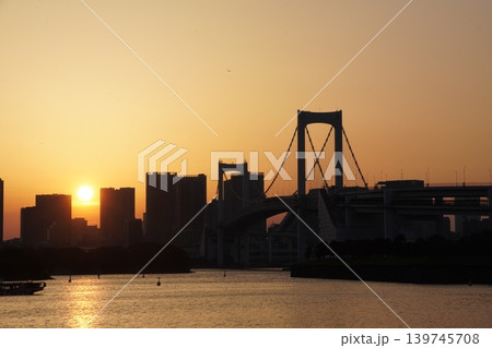 夕日輝くレインボーブリッジと東京湾を美しく染めるサンロードの引きの構図 夕日輝くレインボーブリッジと東京湾を美しく染めるサンロードの引きの構図 139745708