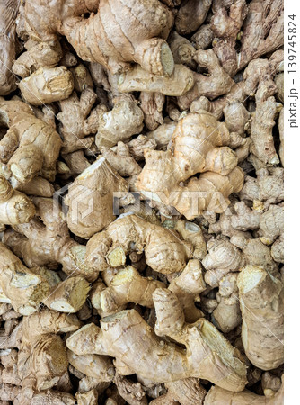 A close up view shows a pile of raw ginger roots placed on display at a market stall. This scene highlights the focus on healthy eating and cooking options available. 139745824
