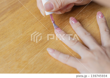 女性が左手の薬指にジェルネイル塗っている 女性が左手の薬指にジェルネイル塗っている 139745934