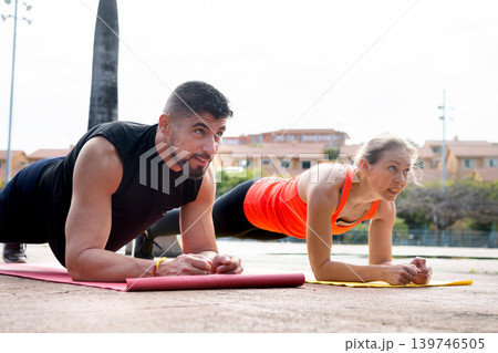 Fit Couple Doing Plank Exercise Outdoors Together Fit Couple Doing Plank Exercise Outdoors Together 139746505