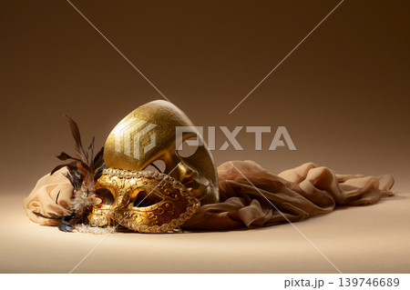 Golden Venetian carnival masks on a beige background. 139746689