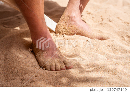 Bare feet covered with sand on beach at Red Sea resort in Sharm El Sheikh Egypt during summer vacation. Travel and relaxation lifestyle Bare feet covered with sand on beach at Red Sea resort in Sharm El Sheikh Egypt during summer vacation. Travel and relaxation lifestyle 139747149