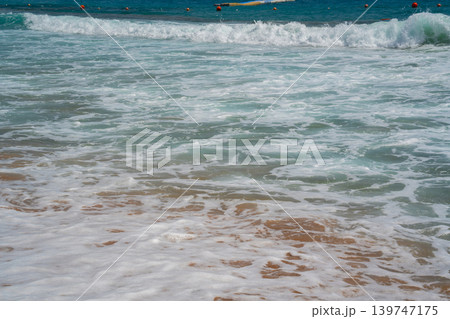 Clear turquoise Red Sea water with white sea foam washing over sandy beach in Sharm El Sheikh Egypt. Travel and resort lifestyle 139747175