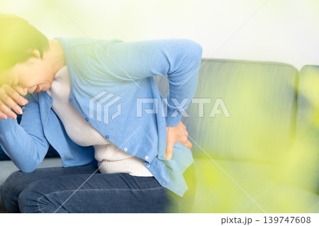 女性　腰痛　手元 139747608