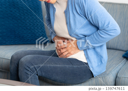 女性　腹痛　手元 139747611