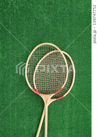 Vintage badminton rackets on green grass top view Vintage badminton rackets on green grass top view 139747752