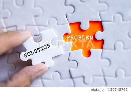 Hand fitting Solution and Problem orange puzzle pieces together on gray jigsaw background, business problem solving and innovation concept 139748763