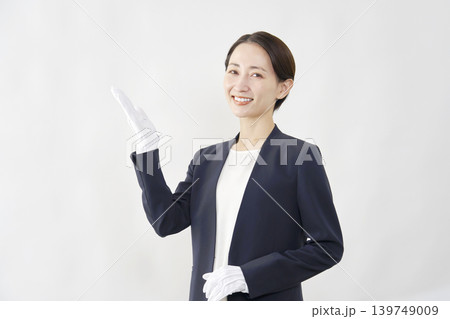 手のひらで左側を指す女性鑑定士 白背景 手のひらで左側を指す女性鑑定士 白背景 139749009