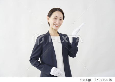 手のひらで右側を指す女性鑑定士　白背景 139749010