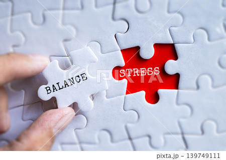 Hand fitting Balance and Stress red puzzle pieces together on gray jigsaw background, mental health and wellbeing management concept Hand fitting Balance and Stress red puzzle pieces together on gray jigsaw background, mental health and wellbeing management concept 139749111