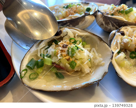 活ホッキ貝のニンニクソース蒸し スプーンでソースをかける 活ホッキ貝のニンニクソース蒸し スプーンでソースをかける 139749328