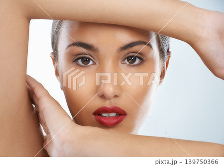 Beauty, confident and portrait of woman in studio with cosmetic and face routine with red lipstick. Self care, makeup and female model with facial cosmetology treatment for glow by gray background. Beauty, confident and portrait of woman in studio with cosmetic and face routine with red lipstick. Self care, makeup and female model with facial cosmetology treatment for glow by gray background. 139750366