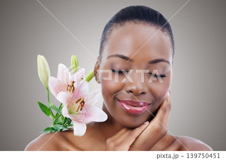 Eyes closed, flower and black woman with cosmetics, skincare and treatment on white studio background. African person, girl and model with natural beauty and grooming with shine, wellness and glow Eyes closed, flower and black woman with cosmetics, skincare and treatment on white studio background. African person, girl and model with natural beauty and grooming with shine, wellness and glow 139750451