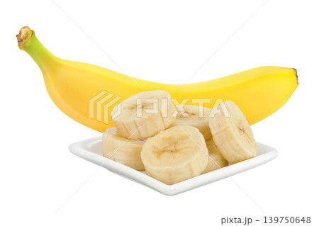 whole and sliced banana in ceramic bowl isolated on white background 139750648