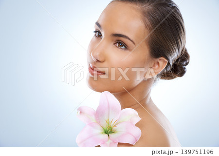 Woman, face and flower in natural skincare, beauty or cosmetics on a blue studio background. Young female person smile with plant or petals on shoulder for glow, care or smooth skin on mockup space Woman, face and flower in natural skincare, beauty or cosmetics on a blue studio background. Young female person smile with plant or petals on shoulder for glow, care or smooth skin on mockup space 139751196