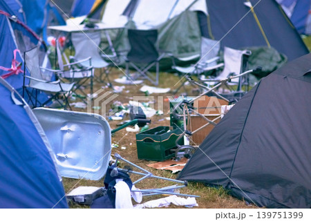 Tents, trash and mess at an outdoor music festival or event for a celebration party or social gathering. Summer, campsite and dirty with untidy camping gear, chairs or cooler boxes on the ground Tents, trash and mess at an outdoor music festival or event for a celebration party or social gathering. Summer, campsite and dirty with untidy camping gear, chairs or cooler boxes on the ground 139751399