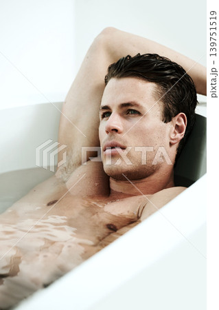 Man, bathtub and face for relax in bathroom with thinking, wellness and contemplating in the morning. Model, person and lying down in bath for self care, grooming and cosmetic routine with topless Man, bathtub and face for relax in bathroom with thinking, wellness and contemplating in the morning. Model, person and lying down in bath for self care, grooming and cosmetic routine with topless 139751519