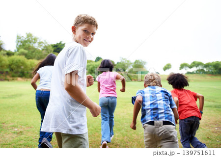 Child, playing and race on field on playground, green grass and sunshine with happiness in city. Young kids, diversity and running game on lawn, summer holiday and leisure with wellness in urban town Child, playing and race on field on playground, green grass and sunshine with happiness in city. Young kids, diversity and running game on lawn, summer holiday and leisure with wellness in urban town 139751611
