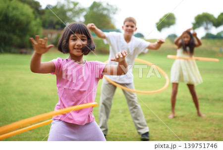 Children, playing and hoop game on field on vacation, green grass and sunshine with happiness in city. Young kids, diversity and play on playground, summer holiday and energy for active in urban town Children, playing and hoop game on field on vacation, green grass and sunshine with happiness in city. Young kids, diversity and play on playground, summer holiday and energy for active in urban town 139751746