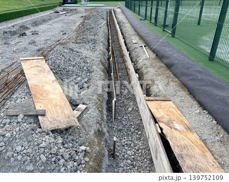 an active construction site situated directly beside a green sports field. Construction of the foundation 139752109