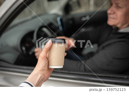 Man Giving Takeaway Coffee Through Car Window 139752123