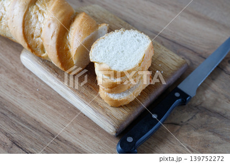 Fresh baguette sliced with a knife. Rustic, handmade rye bread with a golden crust and soft crumb is perfect for cooking, baking 139752272