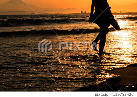 夕日の湘南を歩く女性 139752426