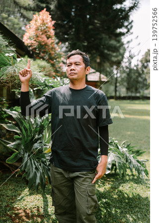 Asian Male Showing Idea Gesture While Pointing Up Outdoors Asian Male Showing Idea Gesture While Pointing Up Outdoors 139752566