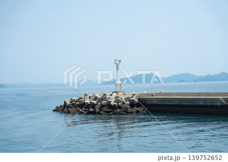 海の安全を守る道標:青空と穏やかな五島列島の海に佇む白い防波堤灯台 海の安全を守る道標:青空と穏やかな五島列島の海に佇む白い防波堤灯台 139752652
