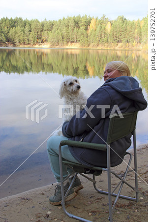 Woman holding cute Maltipoo dog in arms close-up. Woman relaxing with pet Woman holding cute Maltipoo dog in arms close-up. Woman relaxing with pet 139752701