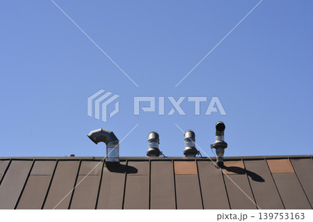 Metal ventilation chimneys on a brown roof Metal ventilation chimneys on a brown roof 139753163