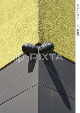 Two Security Cameras on a Building Corner 139753300