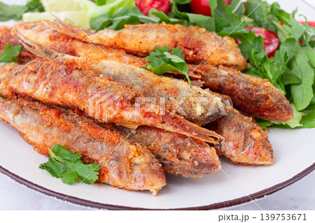 Fried crispy mullet fish, with fresh salad, on a plate with lime, no people, Fried crispy mullet fish, with fresh salad, on a plate with lime, no people, 139753671