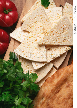 Georgian sliced cheese,on a wooden chopping board, with tomatoes with herbs and lavash, rustic style, Georgian cuisine, no people Georgian sliced cheese,on a wooden chopping board, with tomatoes with herbs and lavash, rustic style, Georgian cuisine, no people 139753678