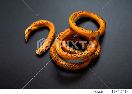 Crunchy bakery rings with poppy seeds on black backdrop Crunchy bakery rings with poppy seeds on black backdrop 139753718