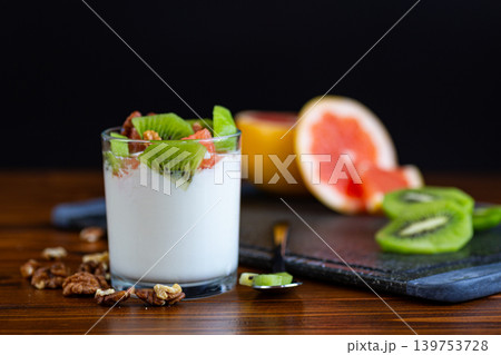 healthy probiotic yogurt with fruits and walnuts on table 139753728