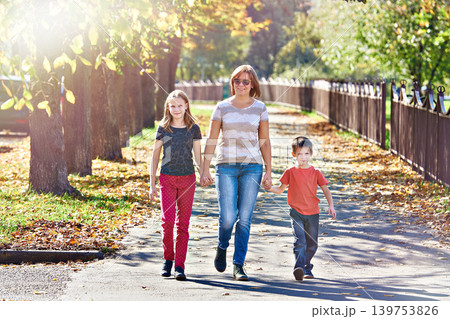 Mother with children walking in autumn park Mother with children walking in autumn park 139753826