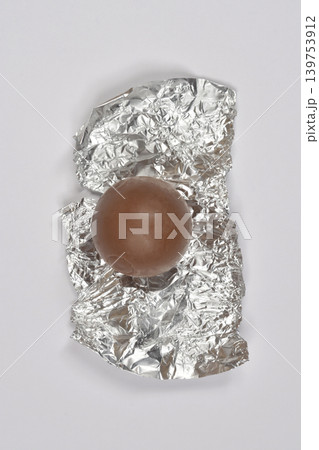 Chocolate ball on silver foil wrapper Chocolate ball on silver foil wrapper 139753912