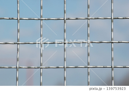 Galvanized Steel Wire Mesh Fence Against Blue Sky Galvanized Steel Wire Mesh Fence Against Blue Sky 139753923