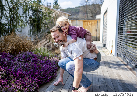 Diabetic dad enjoying playful moment with young son in backyard. 139754018