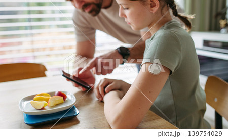 Parent helping diabetic daughter understand nutrition and sugar content. Parent helping diabetic daughter understand nutrition and sugar content. 139754029