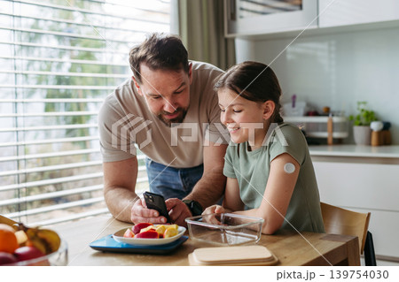 Parent helping diabetic daughter understand nutrition and sugar content. Parent helping diabetic daughter understand nutrition and sugar content. 139754030
