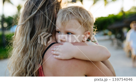 Mother embracing her little daughter in tropical beach resort. 139754046