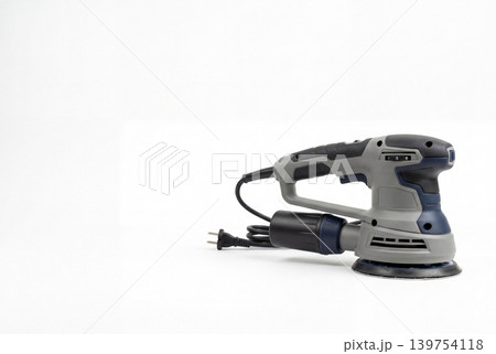 Corded electric orbital sander with dust collection canister and abrasive pad isolated on white background. Professional woodworking, surface finishing, renovation and DIY tool concept. Corded electric orbital sander with dust collection canister and abrasive pad isolated on white background. Professional woodworking, surface finishing, renovation and DIY tool concept. 139754118